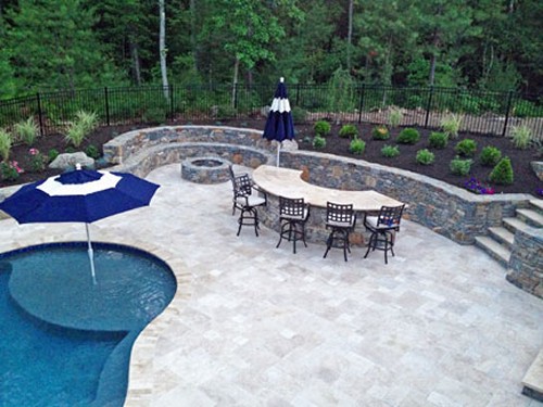 Stone Bar with Tavertine Patio, Sitting Wall with Fire Pit& Pool with Tanning Shelf by New View