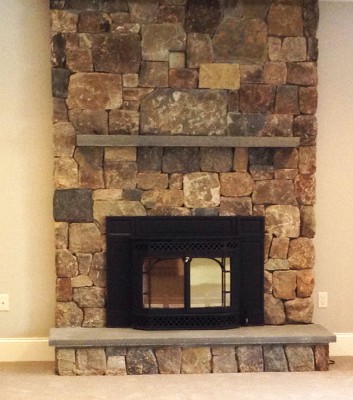 Interior Fieldstone Fireplace Veneer with Blue Stone Mantle, Raised Hearth and Wood Stove Insert by New View