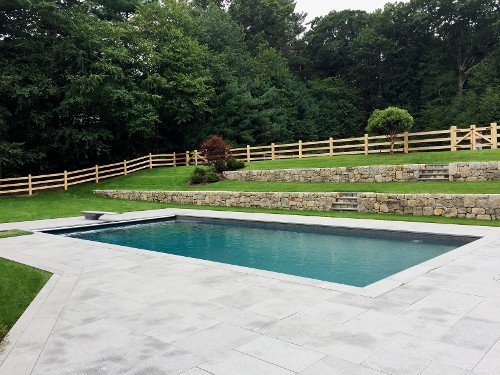 Blue Mist Granite patio and pool coping with field stone retaining walls by New View, Inc.