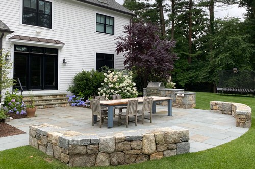 Outdoor Kitchen with stone bar and table by New View