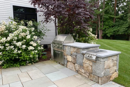 Stone bar with Built in Grill and lower level side burner by New View